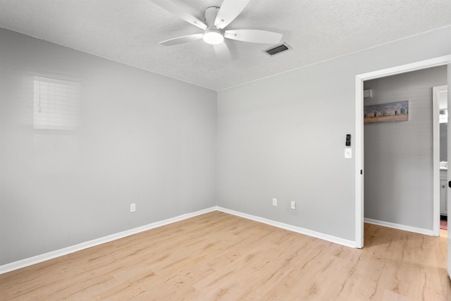 unfurnished room featuring visible vents, a ceiling fan, a textured ceiling, light wood-type flooring, and baseboards