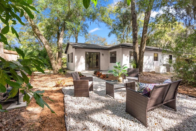 rear view of house featuring cooling unit, a patio, and stucco siding