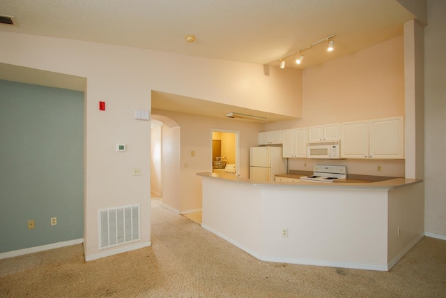 21201 Harbour Vista Cir, Saint Augustine, FL 32080 - kitchen with white appliances, arched walkways, rail lighting, and light carpet
