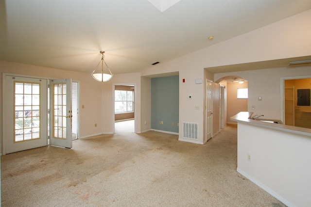 21201 Harbour Vista Cir, Saint Augustine, FL 32080 - unfurnished living room with carpet flooring, arched walkways, vaulted ceiling, and electric panel