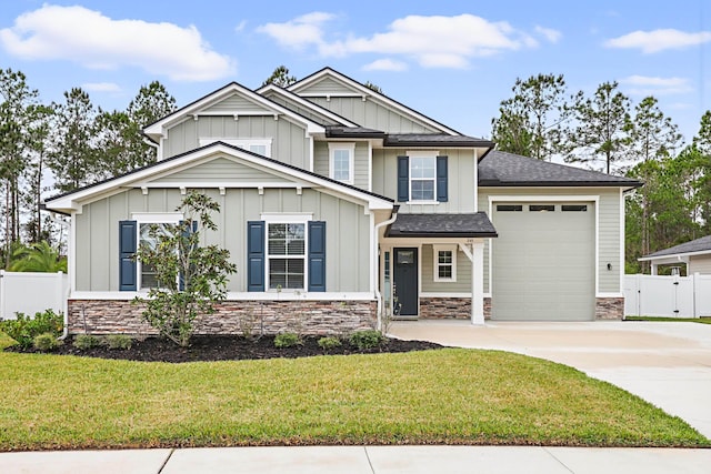 craftsman-style home featuring board and batten siding, stone siding, fence, and a garage