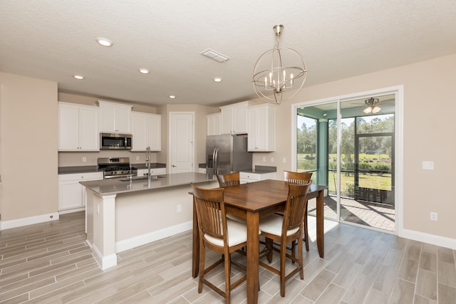 dining room with sink, a textured ceiling, and an inviting chandelier