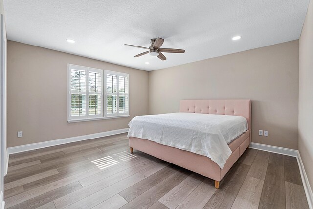 empty room with ceiling fan, a textured ceiling, and light hardwood / wood-style floors