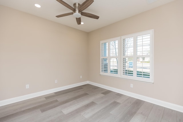 empty room with ceiling fan and light hardwood / wood-style flooring