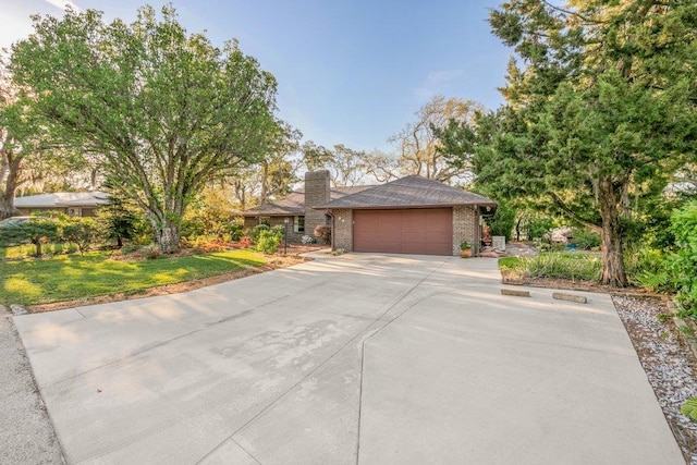 36 Lee Dr, Saint Augustine, FL 32080 - view of front of property with an attached garage, concrete driveway, brick siding, a chimney, and a front yard