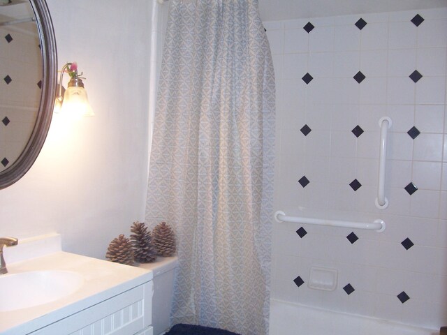 bathroom featuring curtained shower and vanity