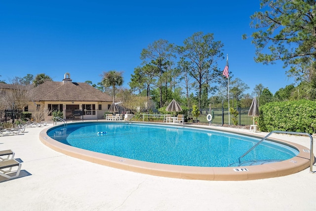 community pool featuring fence and a patio