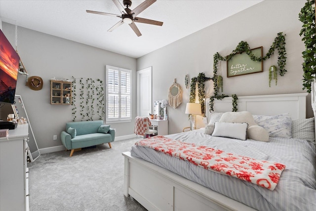 carpeted bedroom with ceiling fan and baseboards