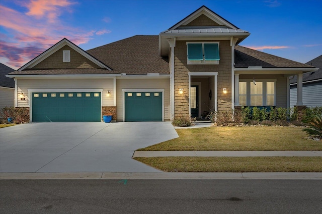 craftsman house with driveway, a lawn, roof with shingles, an attached garage, and a standing seam roof