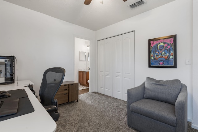 office space with dark colored carpet and ceiling fan