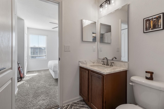 bathroom with toilet, vanity, and ceiling fan