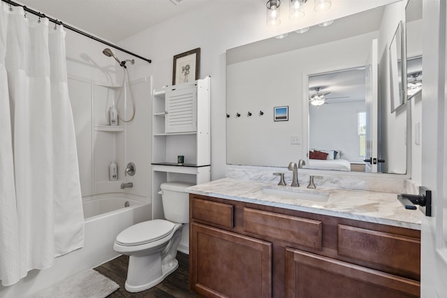 full bathroom with shower / tub combo with curtain, hardwood / wood-style floors, ceiling fan, toilet, and vanity