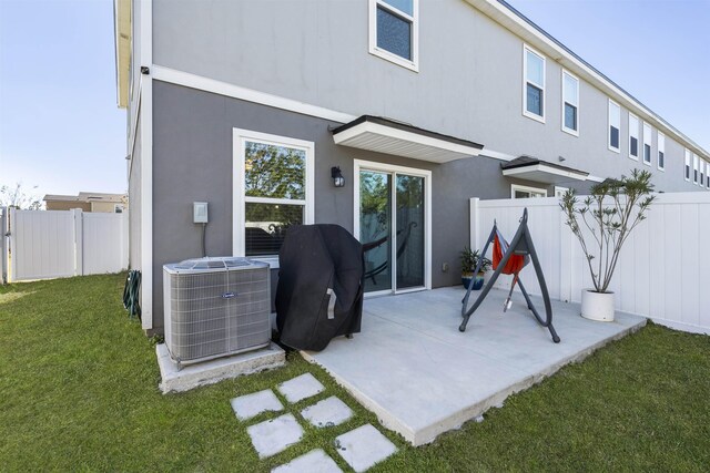 back of house with a lawn, cooling unit, and a patio