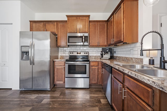 kitchen with sink, stainless steel appliances, dark hardwood / wood-style floors, and tasteful backsplash