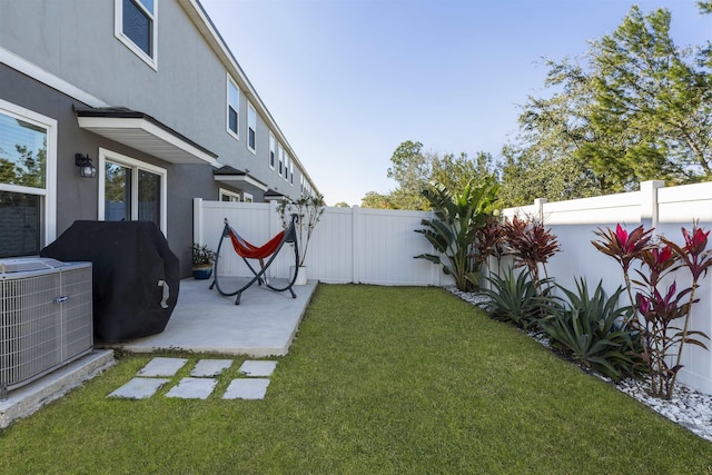 view of yard with central air condition unit and a patio