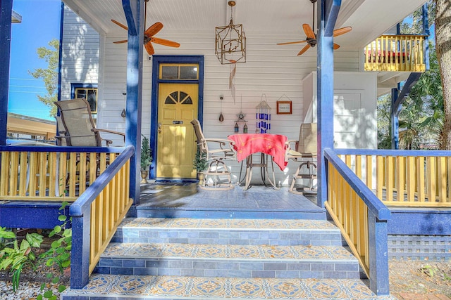 view of exterior entry with ceiling fan and covered porch