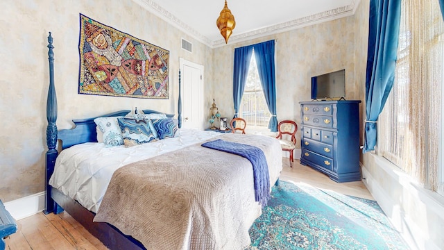 bedroom with crown molding and light hardwood / wood-style flooring