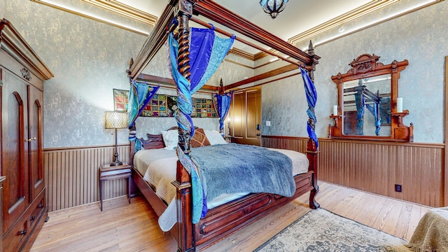 bedroom with crown molding and light hardwood / wood-style floors