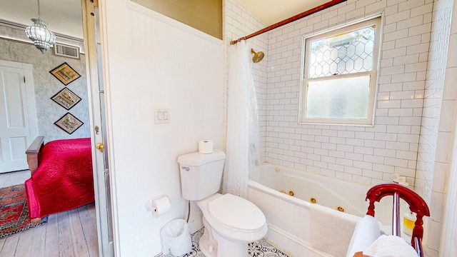 bathroom featuring wood-type flooring, shower / tub combo, and toilet