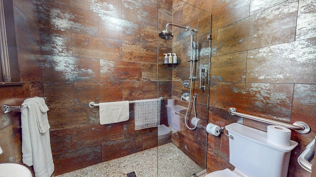 bathroom featuring tiled shower and toilet