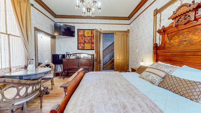 bedroom with crown molding, hardwood / wood-style floors, and an inviting chandelier