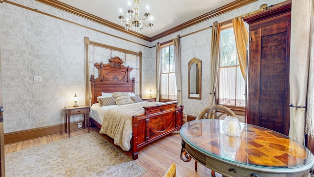 bedroom featuring ornamental molding, light hardwood / wood-style flooring, and a notable chandelier