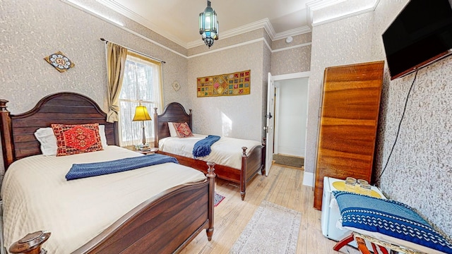 bedroom featuring ornamental molding and light hardwood / wood-style flooring