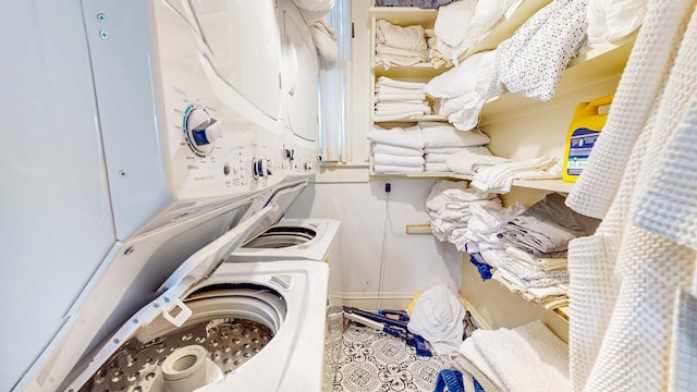 washroom with tile patterned floors and stacked washing maching and dryer