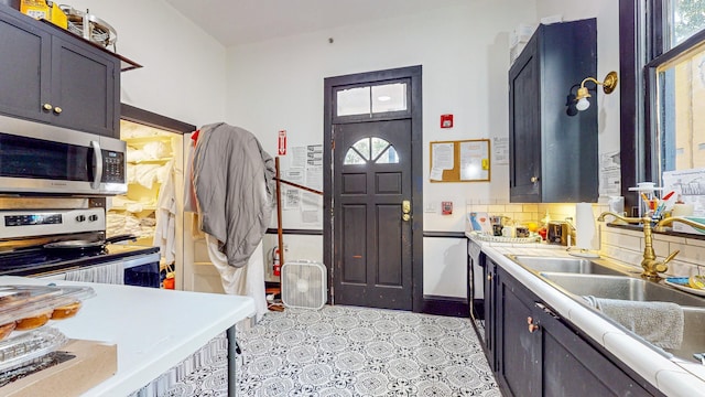 kitchen featuring tasteful backsplash, stainless steel appliances, a wealth of natural light, and sink