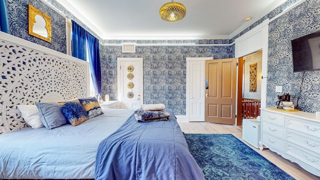 bedroom featuring crown molding and light wood-type flooring