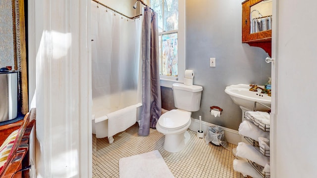 bathroom with tile patterned floors, toilet, and shower / bath combo with shower curtain