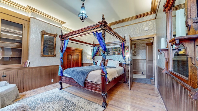 bedroom featuring crown molding and light hardwood / wood-style flooring