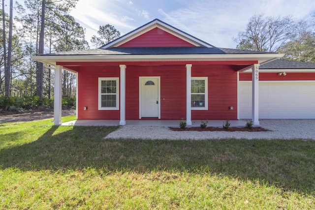 view of front facade featuring covered porch, a garage, and a front yard