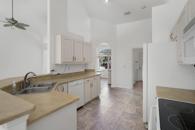 546 Sevilla Dr, Saint Augustine, FL 32086 - kitchen with white dishwasher, a ceiling fan, arched walkways, a high ceiling, and light countertops