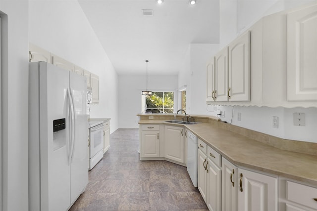 546 Sevilla Dr, Saint Augustine, FL 32086 - kitchen with white appliances, white cabinets, light countertops, and hanging light fixtures