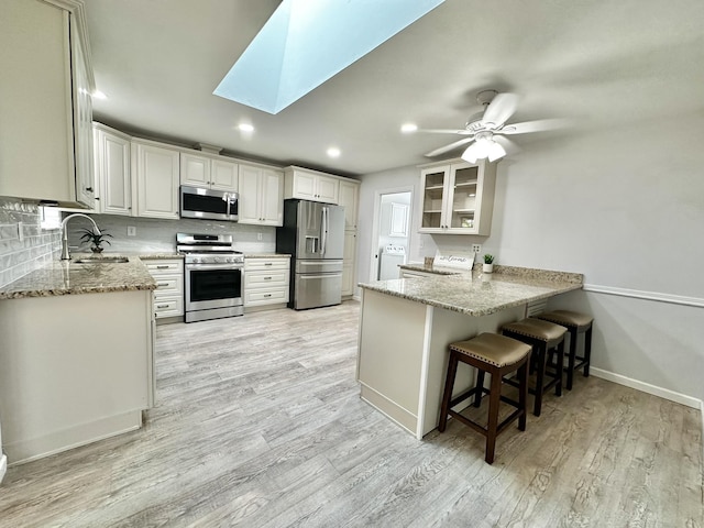 104 Falcon Rd, Saint Augustine, FL 32086 - kitchen with stainless steel appliances, a sink, a peninsula, light stone counters, and recessed lighting
