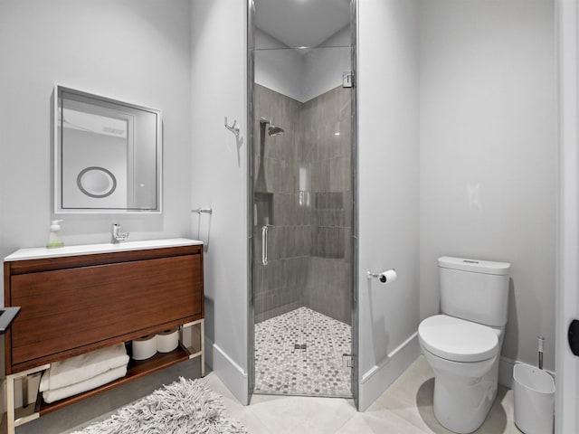 bathroom featuring vanity, toilet, a shower with shower door, and tile patterned flooring