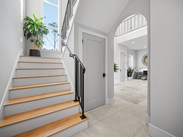 stairs featuring a high ceiling and carpet