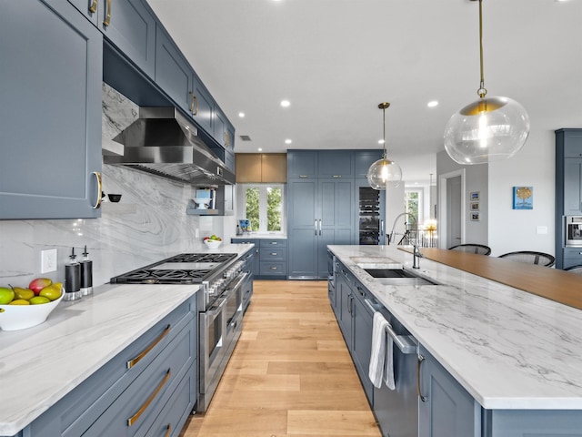 kitchen featuring exhaust hood, appliances with stainless steel finishes, tasteful backsplash, pendant lighting, and a large island with sink