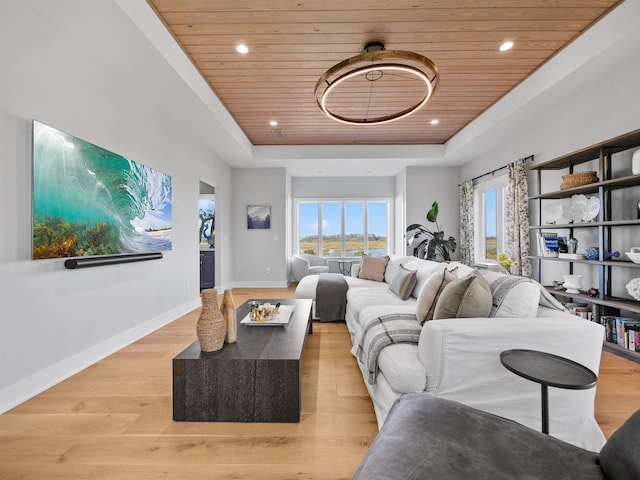 living room with wooden ceiling, light hardwood / wood-style flooring, and a tray ceiling