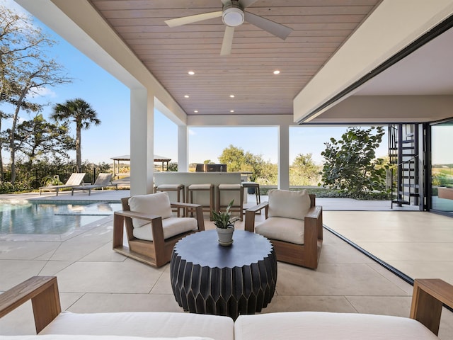 view of patio with outdoor lounge area, ceiling fan, and a bar