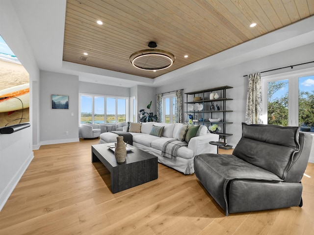 living room featuring a raised ceiling, wood ceiling, and light wood-type flooring