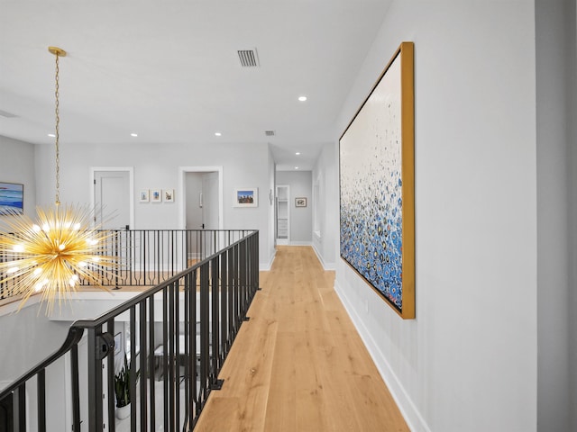 hall featuring hardwood / wood-style floors and a notable chandelier