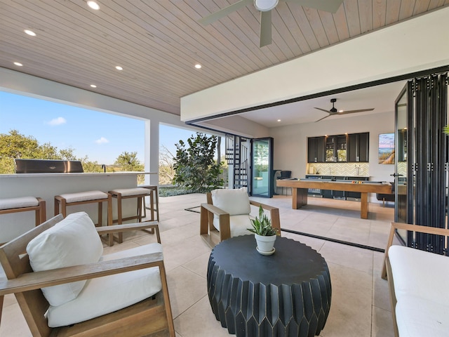 view of patio / terrace featuring exterior bar, an outdoor hangout area, and ceiling fan