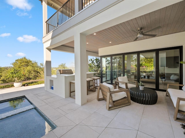 view of patio / terrace featuring an outdoor bar, ceiling fan, area for grilling, a balcony, and grilling area