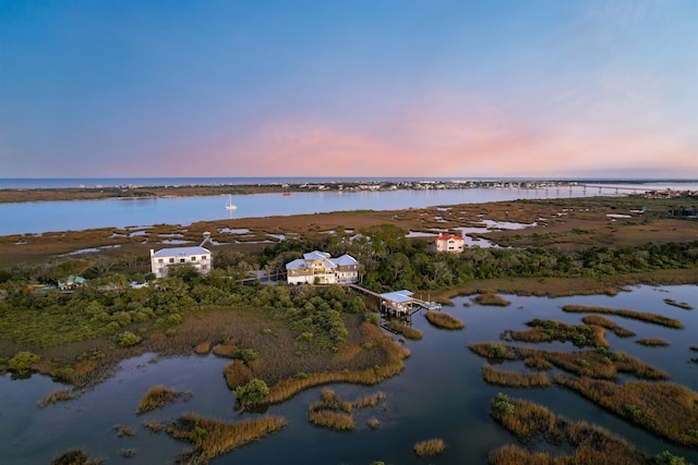 aerial view at dusk featuring a water view