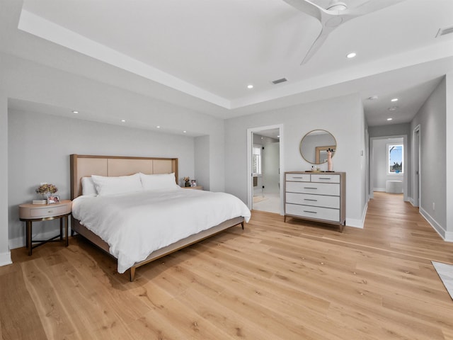 bedroom with ceiling fan, ensuite bath, and light wood-type flooring