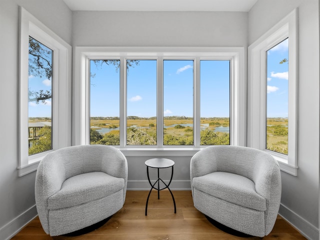 sitting room with wood-type flooring and a water view