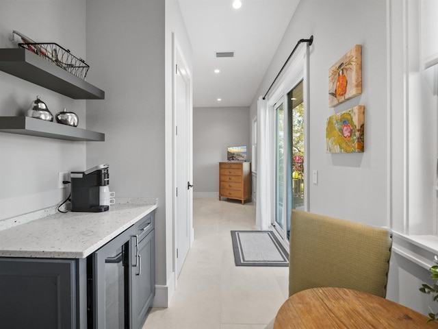 bar with light stone countertops and wine cooler