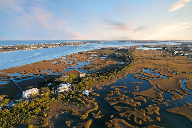 aerial view at dusk featuring a water view